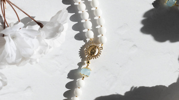 White beaded rosary with gold accents and cross pendant for faithful prayer