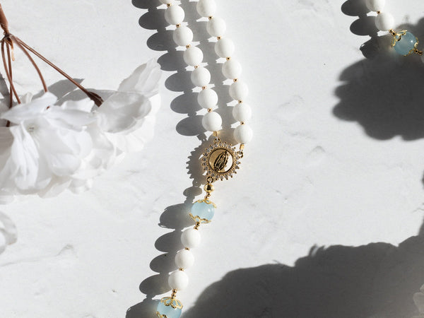 White beaded rosary with gold accents and cross pendant for faithful prayer