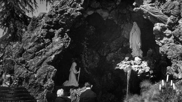 Statue of Virgin Mary in rocky Lourdes grotto for February 11 feast