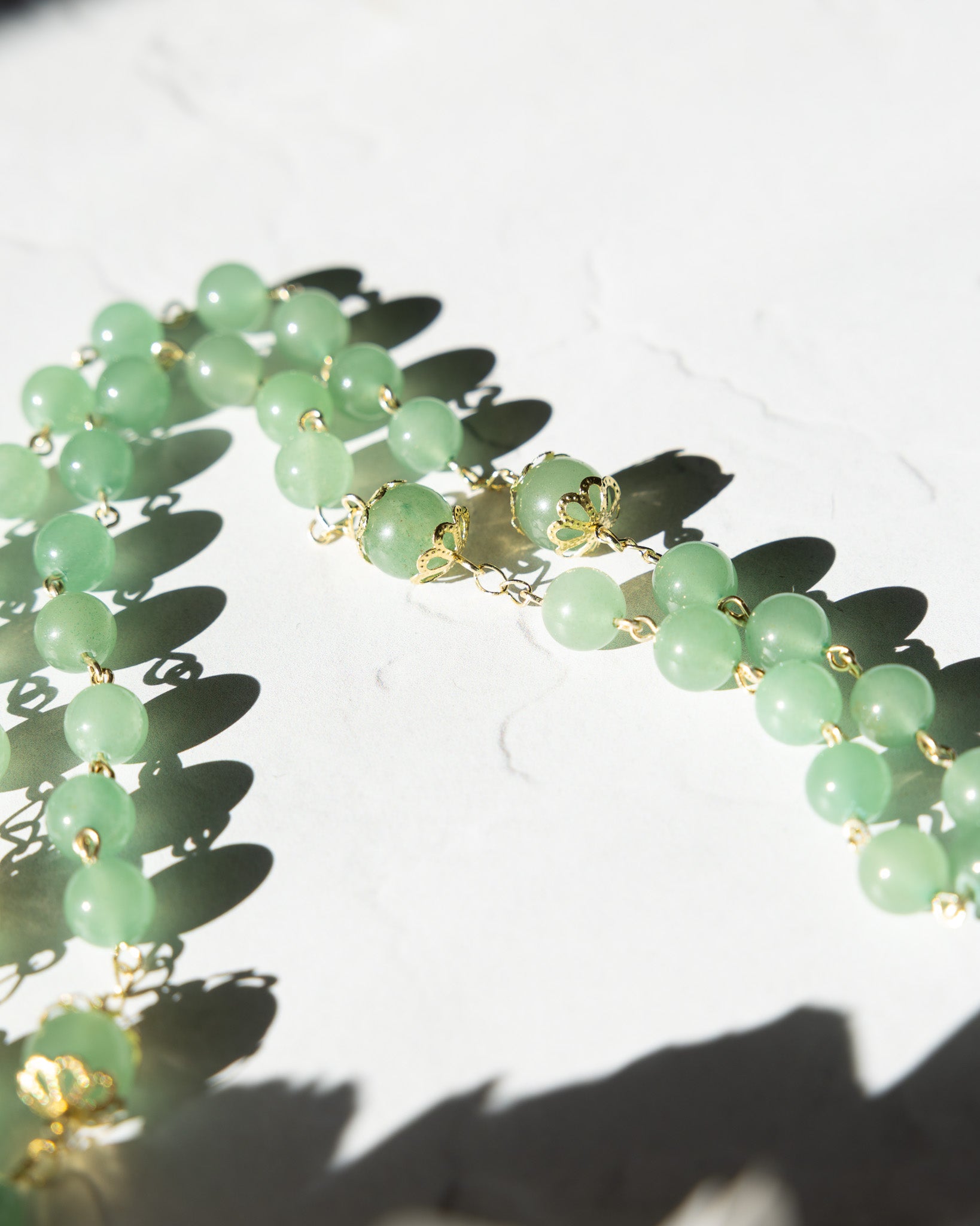 Jadeite Rosary: Delicate green jade beads with gold floral connectors