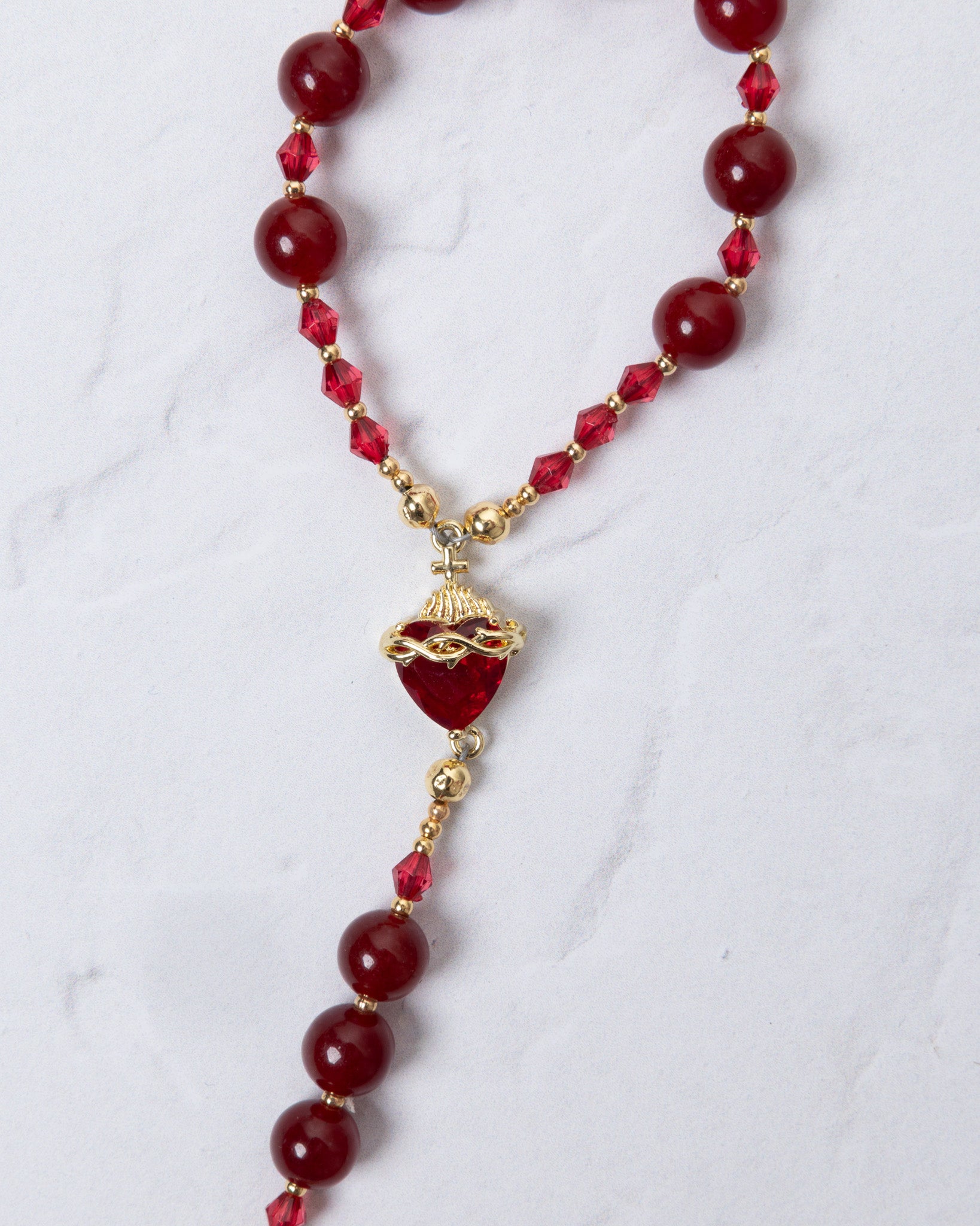 Red heart-shaped pendant necklace with gold accents and red beads for Seven Sorrows Chaplet
