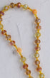 Metamorphosis rosary necklace with faceted amber peach yellow beads and small carved coral rose charms