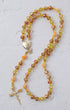 A delicate metamorphosis rosary with faceted amber yellow peach beads and gold heart locket with butterfly charm