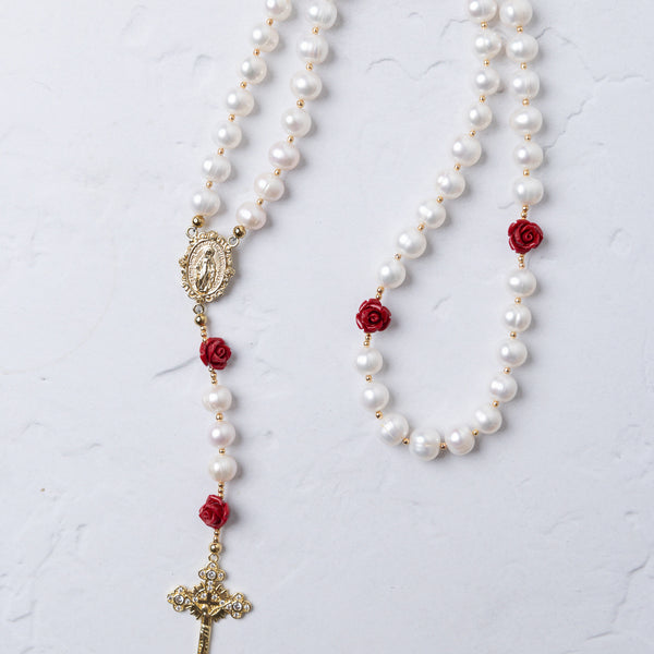 Ivory Rose Pearl Rosary featuring white pearls with red rose accents and gold-toned crucifix and medallion details