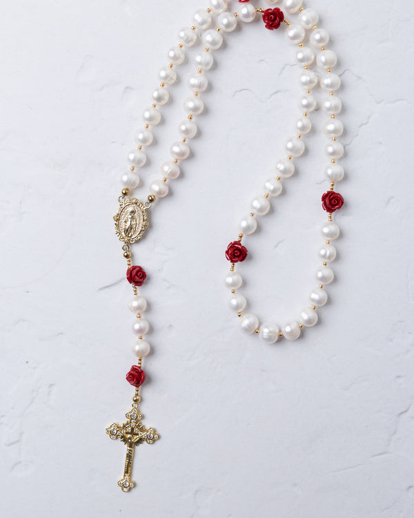 Ivory Rose Pearl Rosary featuring white pearls with red rose accents and gold-toned crucifix and medallion details