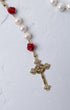 Ivory rose pearl rosary featuring white pearls red rose beads and a gold cross with sparkling stones