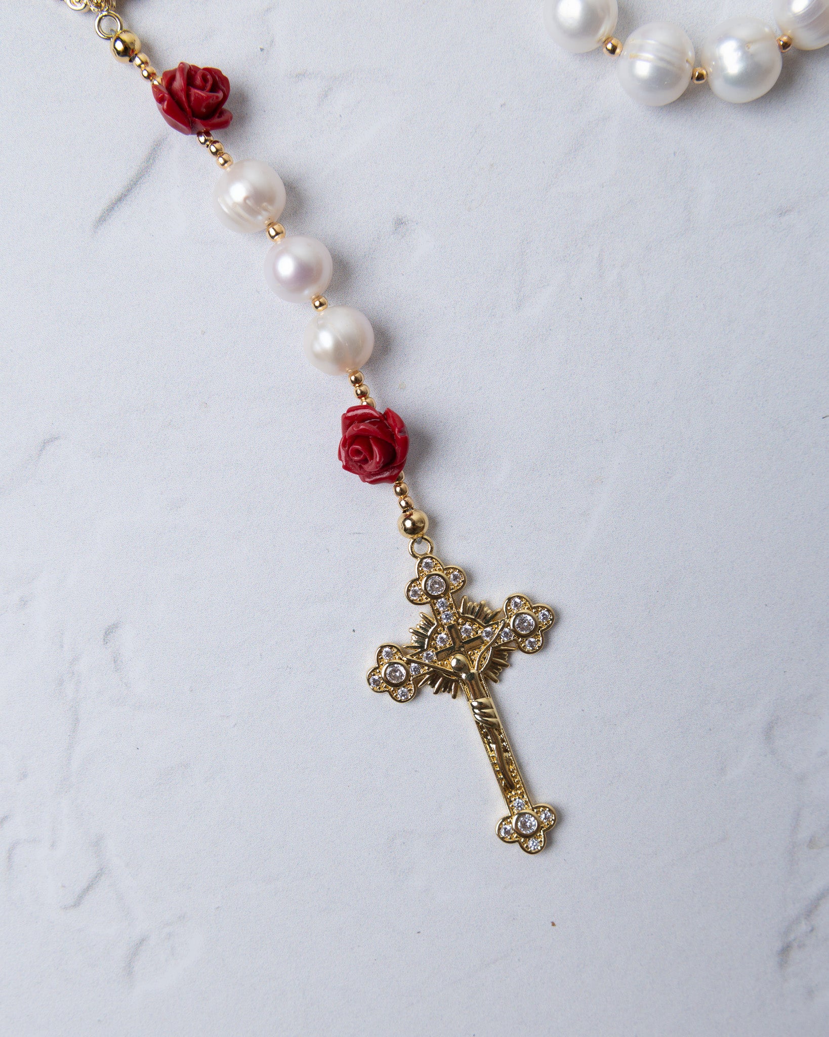 Ivory rose pearl rosary featuring white pearls red rose beads and a gold cross with sparkling stones