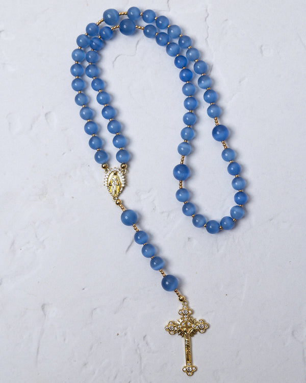 Bluebell rosary featuring delicate blue agate beads with gold-toned metal accents and a detailed cross pendant