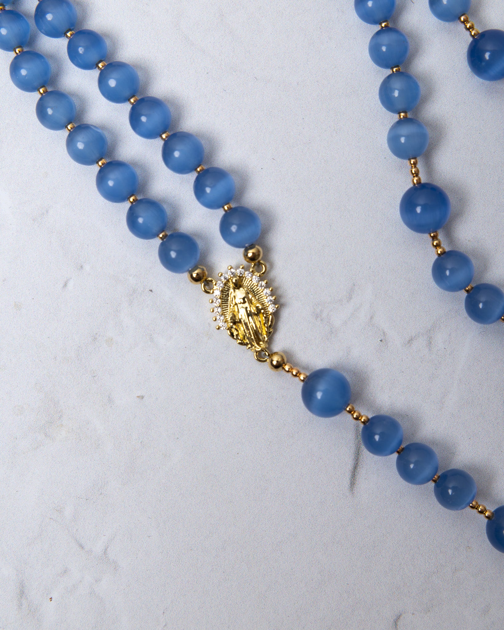 Bluebell rosary with blue translucent beads and a gold-toned our lady of guadalupe medallion