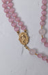 Sweet pea rosary featuring a delicate double-strand design with soft pink rose quartz beads and a gold-toned medallion