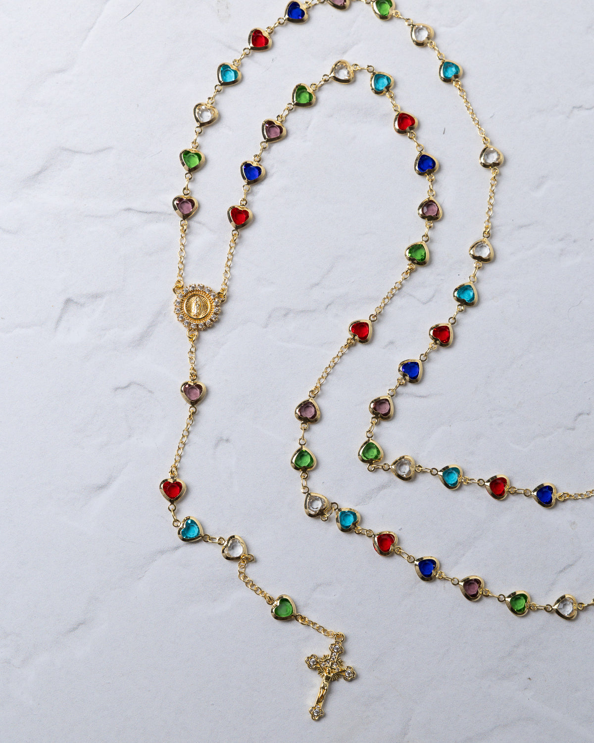 Hearts of Mary rosary gold-toned necklace with colorful heart-shaped beads and an ornate cross pendant on a delicate chain