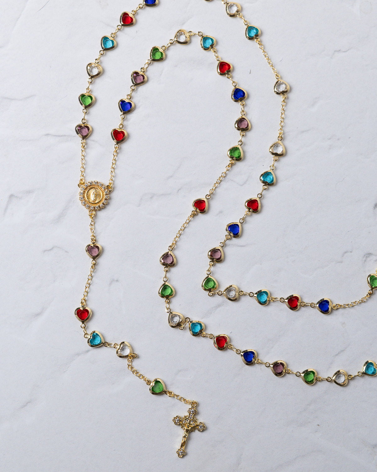 Hearts of mary rosary gold-toned necklace with colorful heart-shaped beads, central medallion, and detailed cross pendant