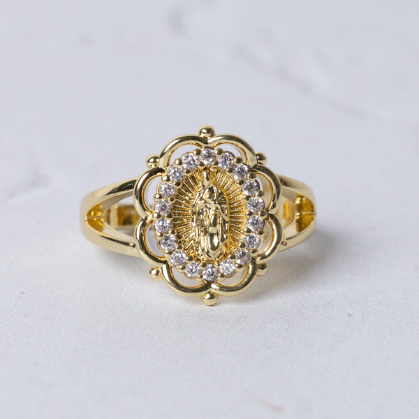 Gold-toned marian halo ring featuring an ornate floral design with a central religious figure and clear stones