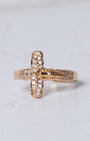 Gold-toned crucifix ring with clear sparkling stones along the cross arms and detailed figure at the center
