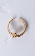 Gold-toned adjustable crucifix ring with central floral design adorned with sparkling clear stones
