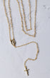 The forever rosary necklace is a gold-toned rosary necklace with a delicate chain and a small oval medallion