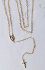 The forever rosary necklace is a gold-toned rosary necklace with a delicate chain and a small oval medallion