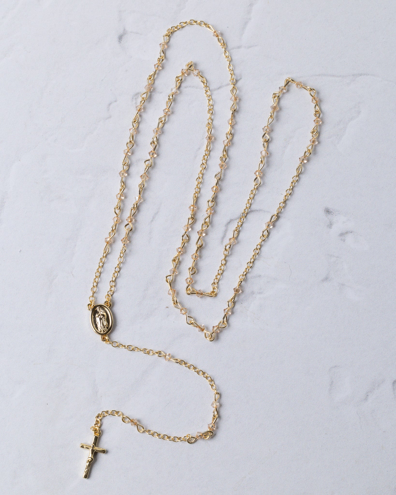 The forever rosary necklace gold-toned chain with detailed oval medallion and small cross pendant at the end