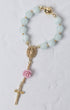 A delicate light blue jade bead rosary bracelet with gold accents featuring a st therese medallion and pink rose charm