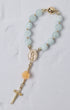 A delicate light blue jade bead bracelet with gold-toned accents and a peach rose charm in st thereses rose garden car rosary