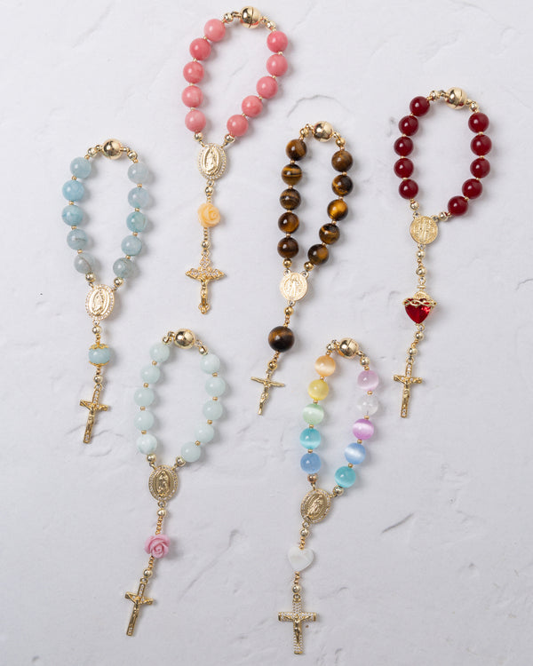 A collection of colorful, handcrafted rosary beads in various gemstone hues and designs.