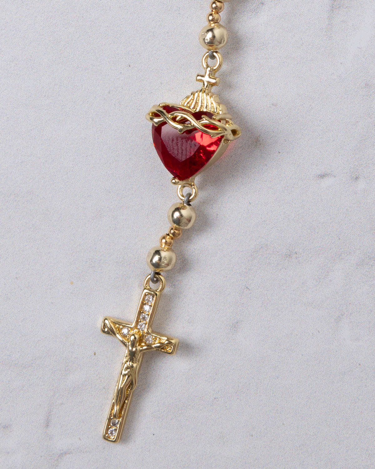 Gold-toned sacred heart steering wheel rosary with a red heart crowned in crystals above a rhinestone crucifix