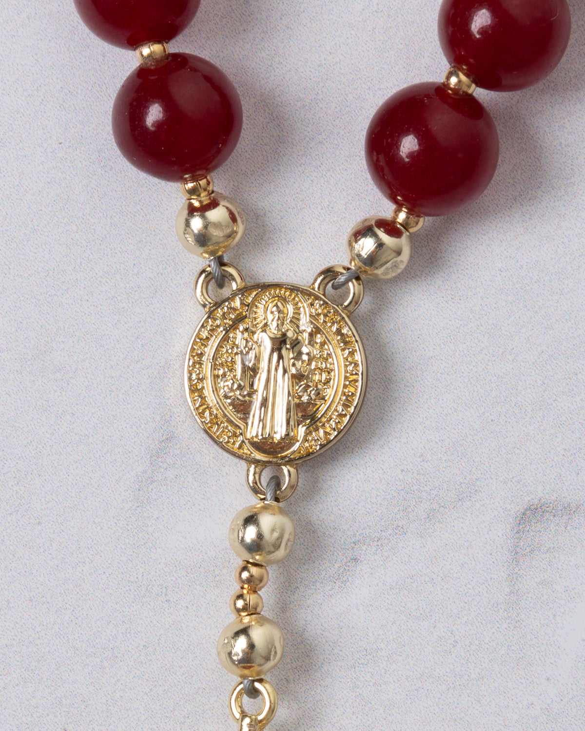 Red agate beads with gold-toned saint benedict medal form a sacred heart steering wheel rosary for prayer use