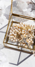 Freshwater pearl wedding lasso rosary displayed in a glass box with a gold cross and floral elements.