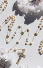 wedding lasso rosary featuring freshwater pearls and gold elements on a soft background with flowers