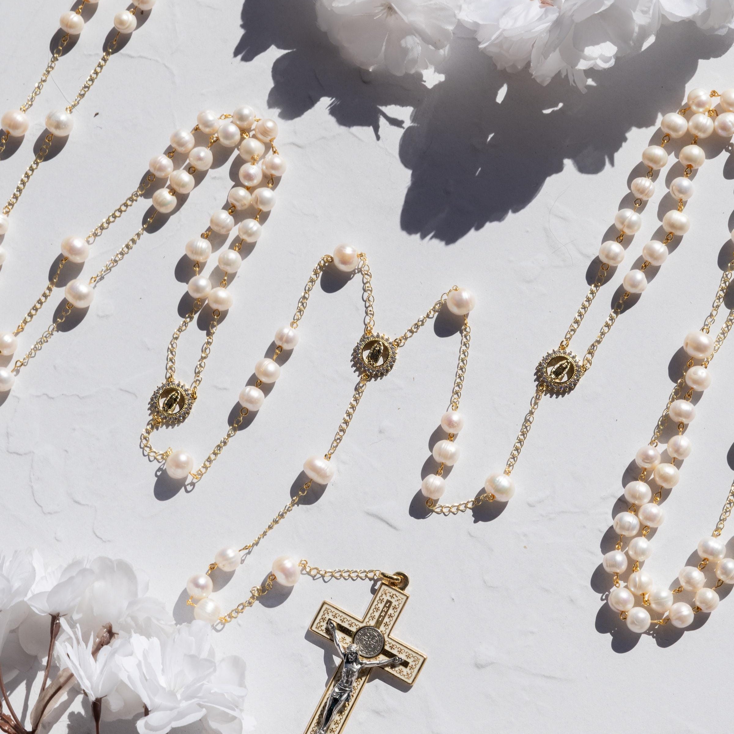 wedding lasso rosary featuring freshwater pearls and gold elements on a soft background with flowers