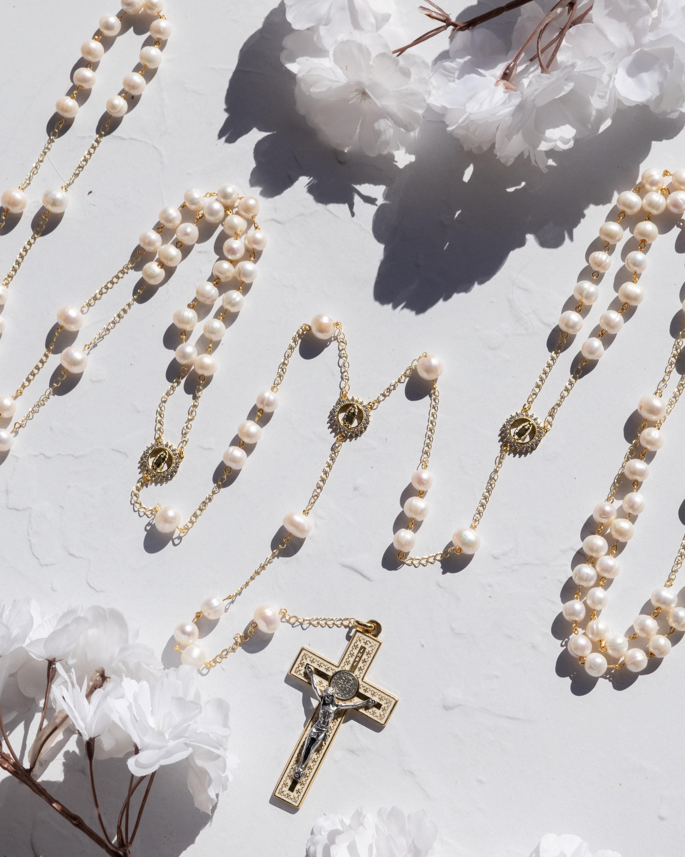 wedding lasso rosary featuring freshwater pearls and gold elements on a soft background with flowers